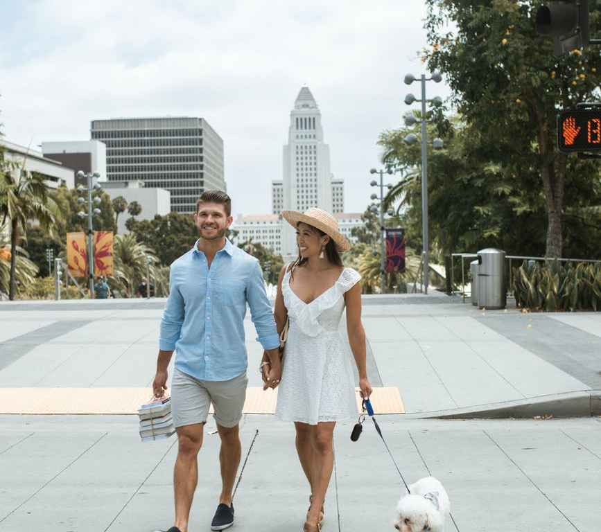 couple holding hands and walking the dog